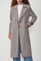 Tapado largo marrón con diseño de espiga, cuello con solapa, cierre con doble botón y bolsillos laterales.