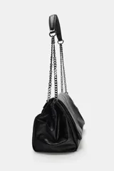 Bolso de hombro con solapa, confeccionado en material sintético con acabado brillante y efecto envejecido. Presenta un diseño estructurado con costuras decorativas, tres compartimentos internos, uno de ellos con cierre de cremallera, y asa de cadena metálica. Se cierra mediante un imán oculto.