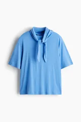 Remera de punto suave de algodón, color celeste, con hombros caídos, mangas cortas y detalle de cuello tipo fular con lazo integrado.