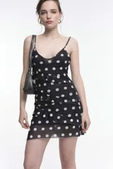 Vestido corto de tirantes finos con estampado de cebra en blanco y negro, escote en V y espalda baja. Presenta volados y frunces que realzan la figura.