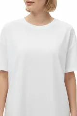 Remera de algodón blanca, de manga corta, cuello redondo y diseño holgado con estampa en el pecho.