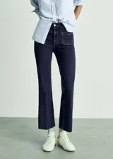 Jeans de tiro medio con diseño acampanado y bolsillos de parche delanteros. Confeccionados en tejido de algodón con elastano, cuentan con cierre frontal de cremallera y botón.