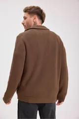 Sweater verde oscuro de punto con cuello alto y cierre de cremallera parcial. Tejido de canalé vertical.