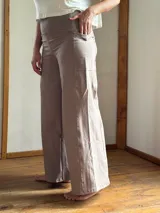 Pantalón palazzo de lycra de algodón color gris claro, de tiro alto, con bolsillos laterales y faja ancha en la cintura.