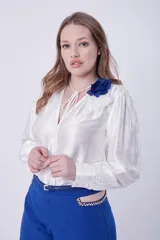 Pantalón palazo azul con detalle de cadena dorada en la cintura.