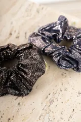 Goma para el pelo tipo scrunchie, color azul marino con acabado brillante o glitter en tono dorado/cobre.