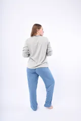 Pijama de dos piezas color coral, de lanilla, compuesto por una camisa de manga larga con botones y un pantalón largo.