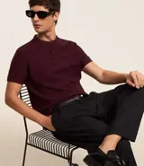 Polo de hombre de manga corta, color beige claro, con cuello mao y tapeta de dos botones.