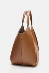 Bolso mini shopper de cuero sintético en color marrón, con diseño estructurado y costuras decorativas contrastantes. Cuenta con doble asa de mano y cierre magnético.