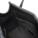 Cartera chica tipo tote de lona gris con detalles en cuero sintético negro, doble asa de mano y bolsillo frontal con cierre y el logo de la marca Extra Large.