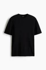 Remera de punto acanalado fino color negro, con cuello redondo y mangas cortas, de corte slim fit.