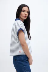 Remera con cuello tipo polo y escote en V, a rayas horizontales color beige y blanco, con cuello y mangas color beige liso.