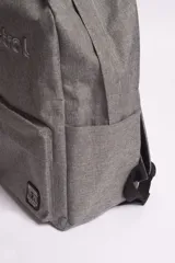 Mochila azul con logo bordado, bolsillos externos y bolsillo escondido al dorso con cierre.