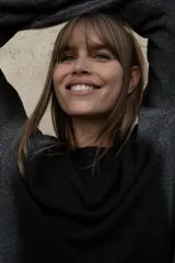 Jersey de punto con cuello redondo amplio y manga larga, presentando un efecto difuminado o degradado en tonos oscuros, posiblemente negro y gris.