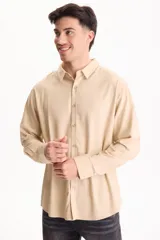 Camisa de lino de manga larga, color beige, con cuello clásico y cierre frontal de botones.