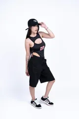 Body negro con recorte en el pecho y estampado del número 28 en rosa. Short negro de jean con bolsillos.