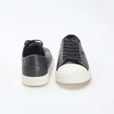 Zapatillas urbanas bajas de cuero sintético negro con puntera de goma blanca y cordones negros.