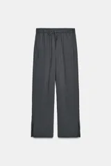 Pantalón de tiro medio con diseño de pierna ancha y estampado de rayas verticales. Cuenta con cintura elástica ajustable mediante cordones y bolsillos laterales ocultos en la costura, con aberturas en el bajo.