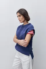 Chaleco tejido azul de calce relajado, silueta recta, cuello redondo, hombros caídos y diseño de punto con textura calada.