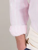 Camisa de hombre de algodón orgánico a rayas verticales rosas y blancas, de corte regular fit, cuello button-down, cierre con botones, manga larga terminada en puño simple y logo bordado en el pecho.