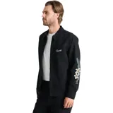 Campera negra de estilo workwear con cierre frontal, cuello camisero y bordados florales en las mangas. Presenta el logo de la marca bordado en el pecho.