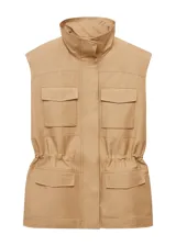 Chaleco oversize color beige, sin mangas, con cuello de solapa, cuatro bolsillos de parche con solapa en la parte delantera, fruncido elástico en la cintura y cierre frontal con botones.