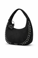 Cartera tipo hobo bag color negro, con detalles de tachas plateadas en los bordes y un charm colgante en forma de corazón también con tachas.