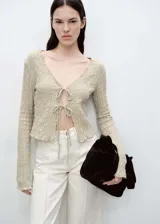 Cardigan de manga larga con textura arrugada, cuello en pico y cierre frontal mediante lazos. Confeccionado en tejido mezcla de algodón.