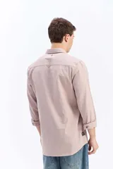 Camisa de manga larga color gris oscuro, confeccionada en tejido liviano con textura sutil, cuello tradicional y cierre frontal de botones.