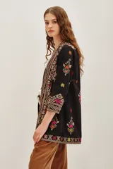 Kimono negro de algodón con bordados étnicos multicolores en el frente, mangas y ruedo. Posee un diseño abierto y mangas tres cuartos.
