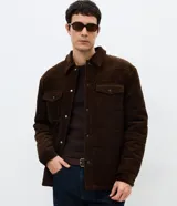 Campera puffer de Marfinno confeccionada en tejido de terciopelo cotelé. Presenta diseño acolchado, cuello inglés, cierre frontal con botones, dos bolsillos con solapa en el pecho y mangas largas con puños abotonados.