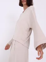 Sweater color visón con escote en V y corte asimétrico.