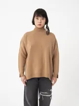 Sweater de tejido fino color marrón con cuello alto y manga larga. Cuenta con un detalle de costura vertical en el frente, hombros caídos y pequeñas aberturas en los puños.