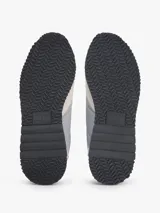 Zapatillas runner Tommy Jeans Eva de estilo urbano, confeccionadas con una combinación de textil, cuero y material sintético en tonos gris, beige y negro. Cuentan con cordones negros, suela bicolor y detalles de la marca.