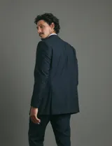 Traje de corte clásico compuesto por saco de dos botones y pantalón de vestir a juego. Diseño tradicional en color negro.