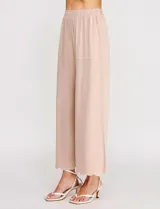 Pantalón palazzo de tiro alto color beige, confeccionado en mezcla de lino y viscosa, con silueta suelta y fluida, cintura elastizada, bolsillos delanteros aplicados y ruedo festoneado de corte tobillero.