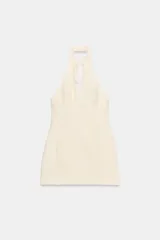 Vestido corto de cuello halter con abertura frontal y lazada, espalda descubierta y falda con bajo acabado en volumen. Incluye cierre de cremallera oculto en la espalda.