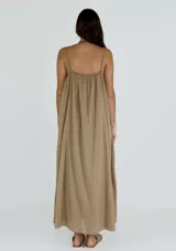 Vestido largo de tirantes finos, con escote en V y detalle de puntilla en el borde. Presenta un diseño holgado y fluido con caída suave.