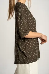 Remerón oversize color verde militar con estampado de lunares blancos, de mangas cortas y cuello redondo.
