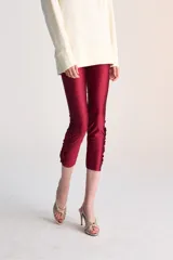 Pantalón capri de lycra color borgoña, con corte ajustado, tiro medio, piernas rectas y detalle de volados en el ruedo.