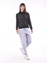 Saco de tejido de punto negro con rayas horizontales blancas, cuello en V y cierre frontal con botones dorados.