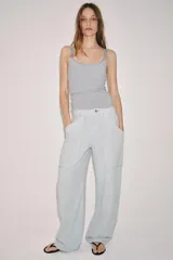 Pantalón cargo de tiro medio, confeccionado en mezcla de algodón y lino, con perneras anchas, bolsillos de plastrón en el delantero y cierre frontal con cremallera y botón.