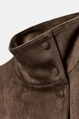 Chaqueta de gamuza sintética color marrón, con cuello subido, cierre frontal cruzado con botones y mangas largas anchas. Cuenta con bolsillos delanteros y cinturón ajustable del mismo tejido.