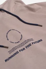 Canguro de felpa color beige con capucha ajustable, bolsillo tipo canguro y puños. Presenta un estampado frontal con texto en azul que incluye "WE ARE BUILDING THE FUTURE" y "RUNNING FOR THE FUTURE".