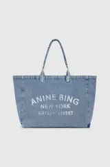 Tote bag de denim azul con estampado frontal en color blanco que incluye el logo de la marca Anine Bing y la leyenda 'New York Greene Street'. Cuenta con dos asas superiores.