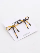 Par de caravanas con forma de moño confeccionadas en tela blanca traslúcida con detalles brillantes.