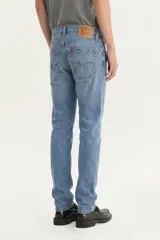 Jeans Levi's modelo 512 Slim Taper de corte entallado, color celeste con sutiles desgastes, tiro medio y cierre de botones.