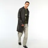 Parka larga negra con capucha y efecto cascada, de material sintético impermeable.