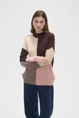 Sweater de punto con diseño de bloques de color en tonos marrón, beige y rosado, de corte holgado, cuello alto y mangas largas.