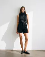 Zapato de cuero negro con diseño de punta cuadrada, laterales abiertos y costura artesanal en hilo beige a contratono. Cuenta con taco bajo.
